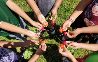 Children holding produce in a circle