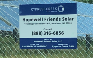 A large sign on a fence for Hopewell Friends Solar from Cypress Creek Renewables