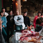 person demonstrating how to butcher meat