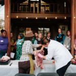 two people demonstrating how to butcher meat in front of audience