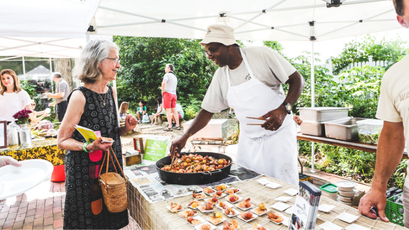 Chef handing out seafood plate to woman at picnic