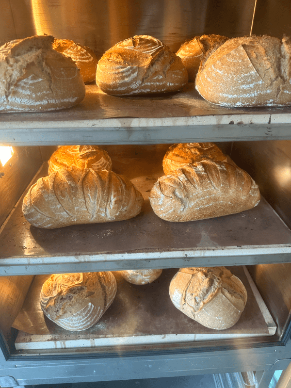 loaves of fresh bread cooling on baking racks
